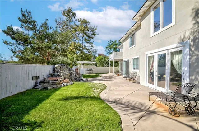 a view of a backyard with plants and brick wall