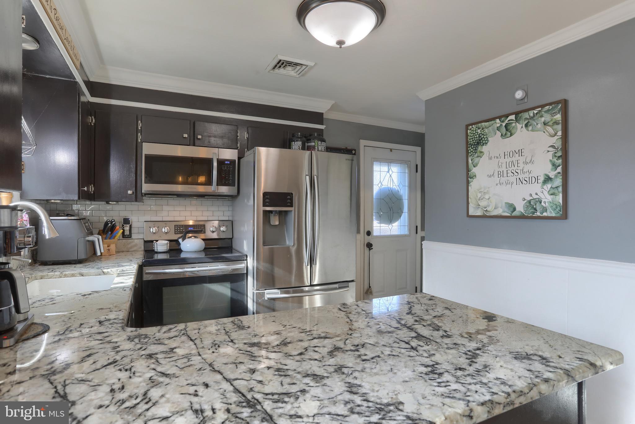 3032 Tunnel Hill Road Lebanon, PA 17046 - Photo 13 of 52 a kitchen with stainless steel appliances kitchen island granite countertop a refrigerator stove and sink