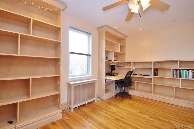 a view of a workspace with furniture and a window