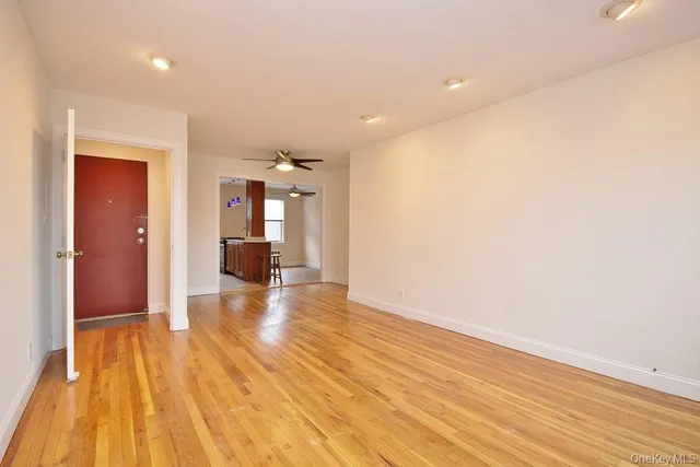 a view of a room with wooden floor and a kitchen