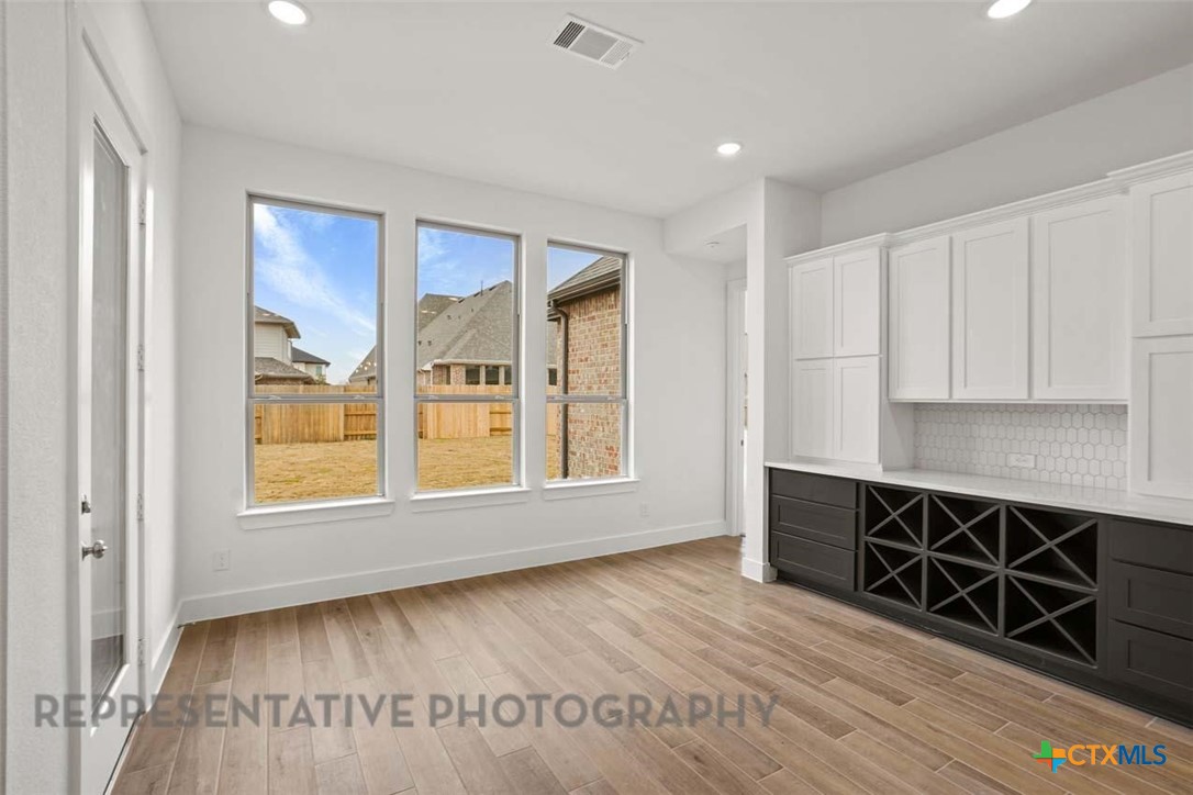 129 Ribera Drive Liberty Hill, TX 78642 - Photo 15 of 23 a view of an empty room with wooden floor and a window