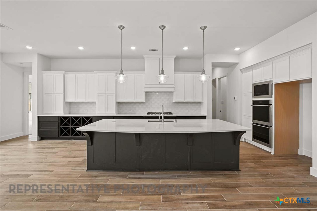 129 Ribera Drive Liberty Hill, TX 78642 - Photo 2 of 23 a large kitchen with kitchen island a sink stainless steel appliances and cabinets