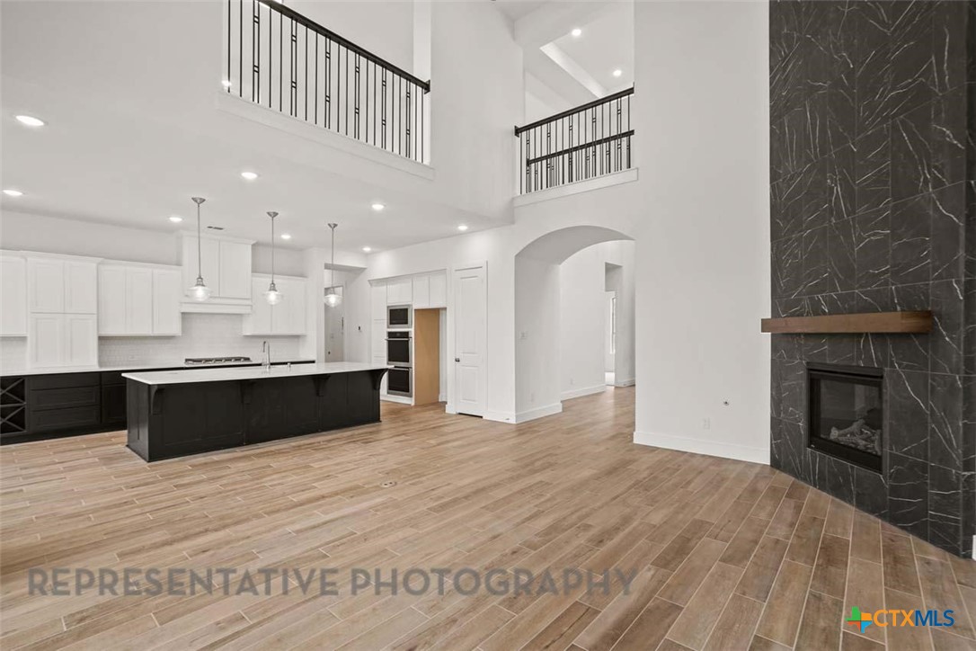 129 Ribera Drive Liberty Hill, TX 78642 - Photo 6 of 23 a view of kitchen with kitchen island wooden floor and living room