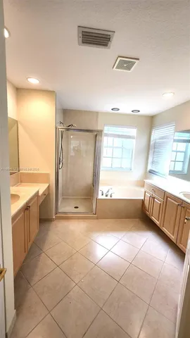 a bathroom with a granite countertop sink mirror bathtub and shower