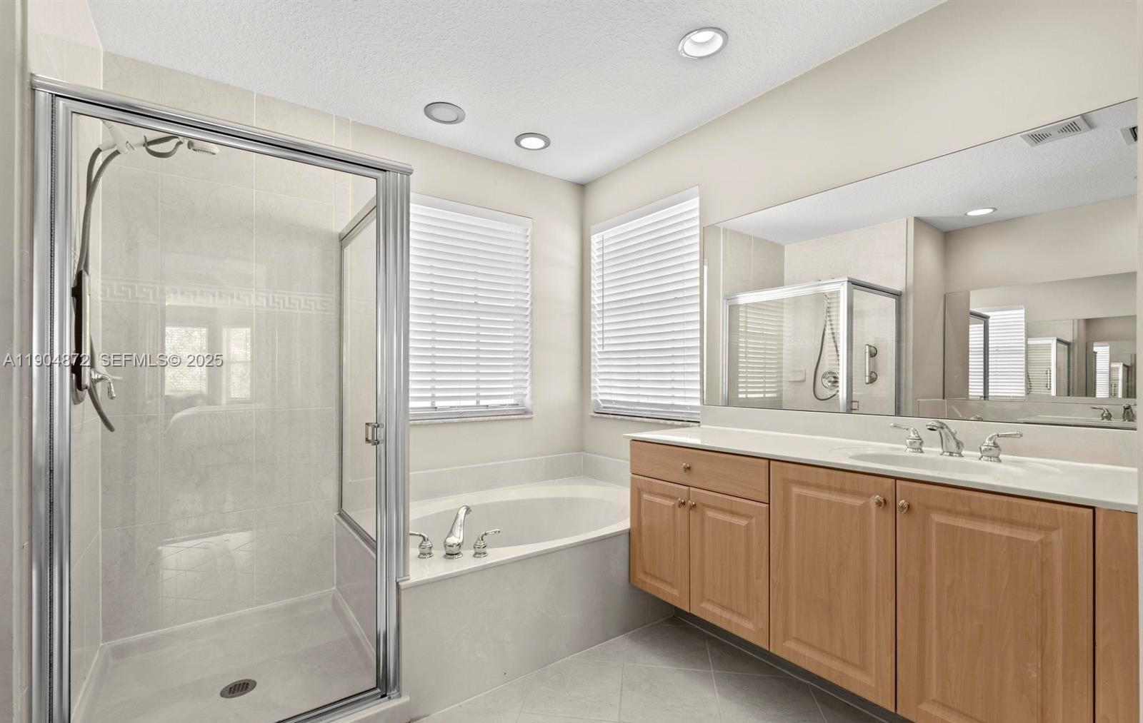 9042 Dupont Place Wellington, FL 33414 - Photo 17 of 43 a bathroom with a granite countertop sink mirror bathtub and shower