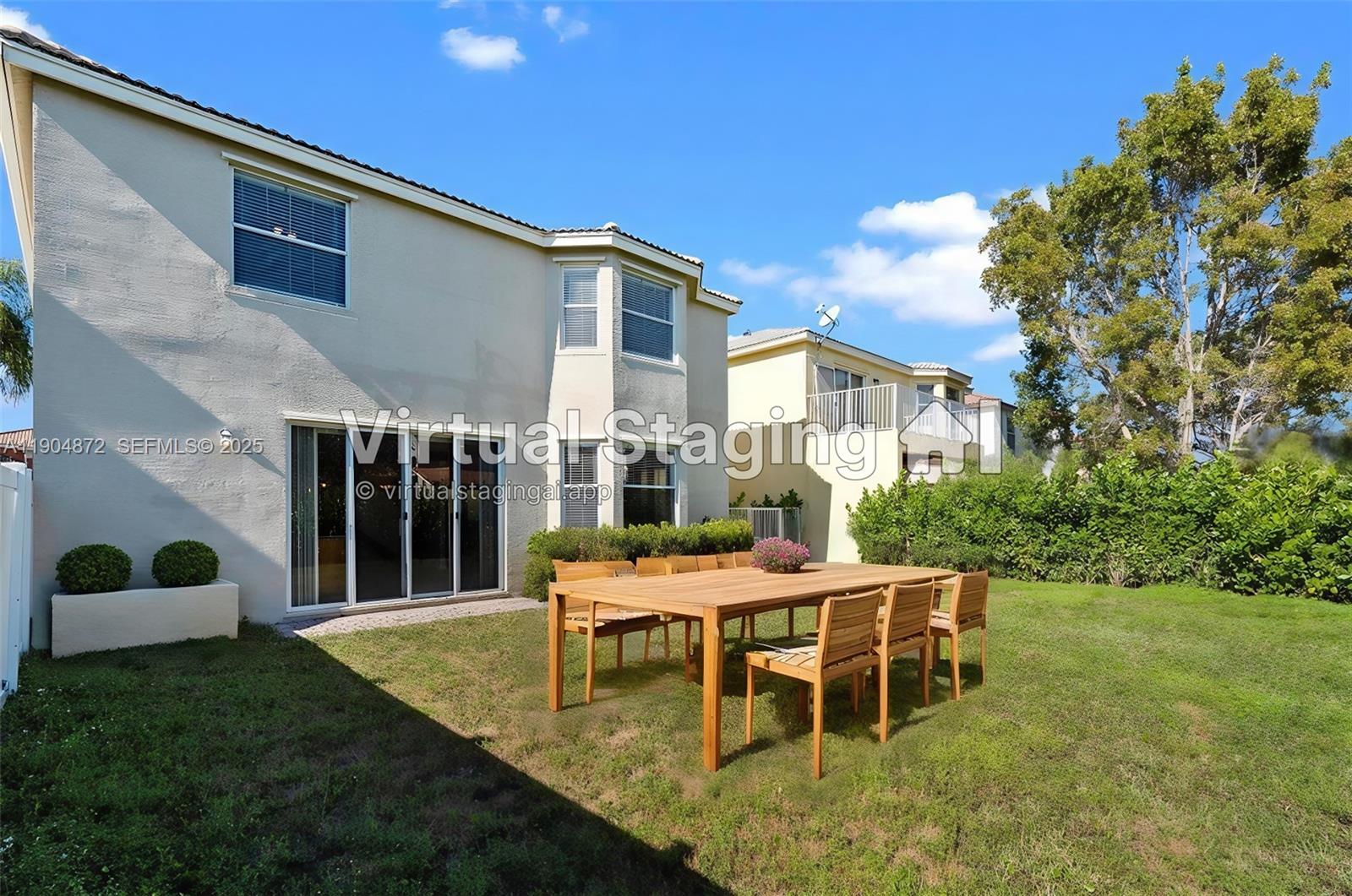 9042 Dupont Place Wellington, FL 33414 - Photo 41 of 43 a backyard of a house with table and chairs
