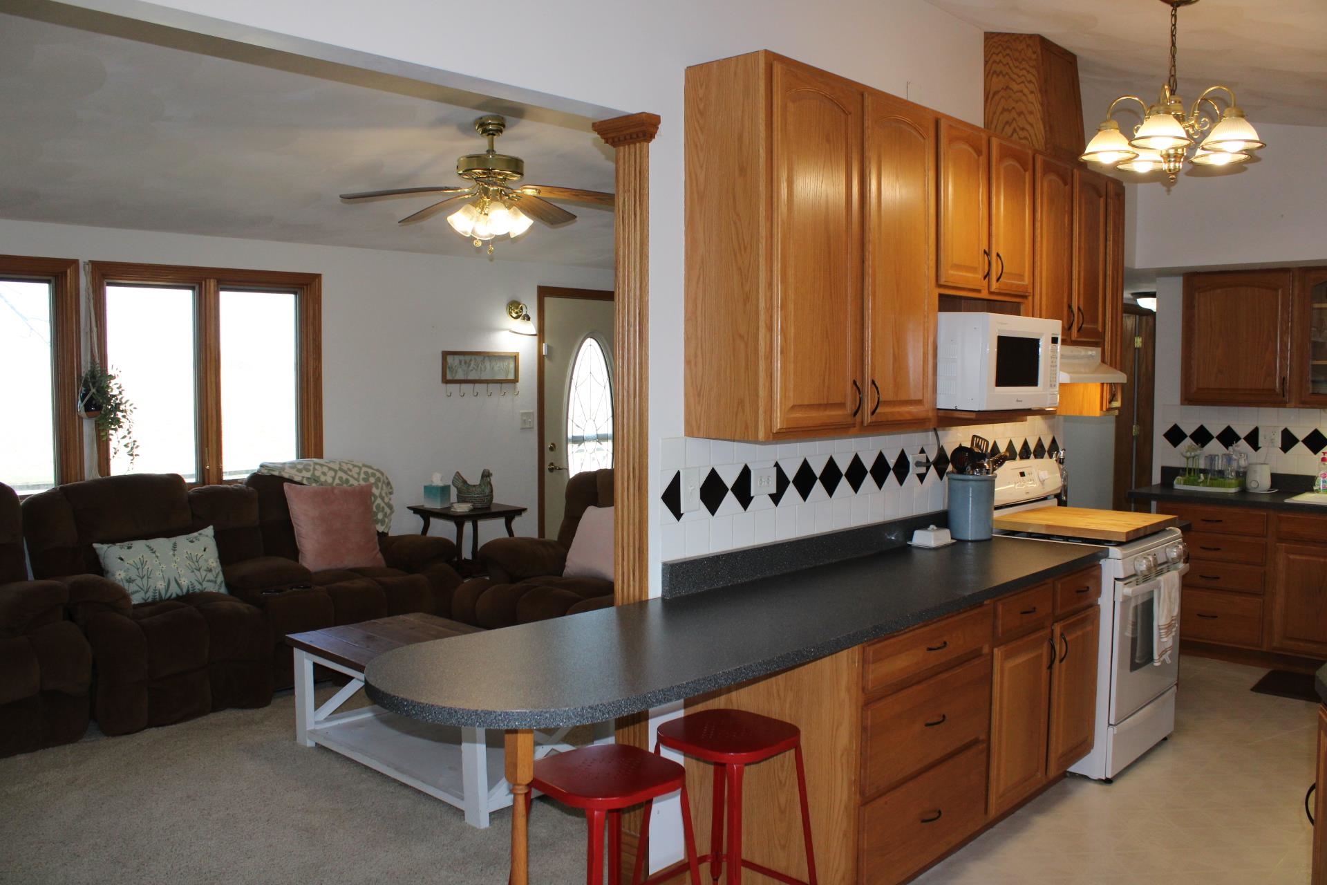 14251 West Kent Road Kent, IL 61044 - Photo 19 of 35 a kitchen with stainless steel appliances kitchen island granite countertop a table chairs in it and a window