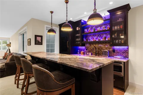 a room with granite countertop a sink a stove and a dining table with chairs