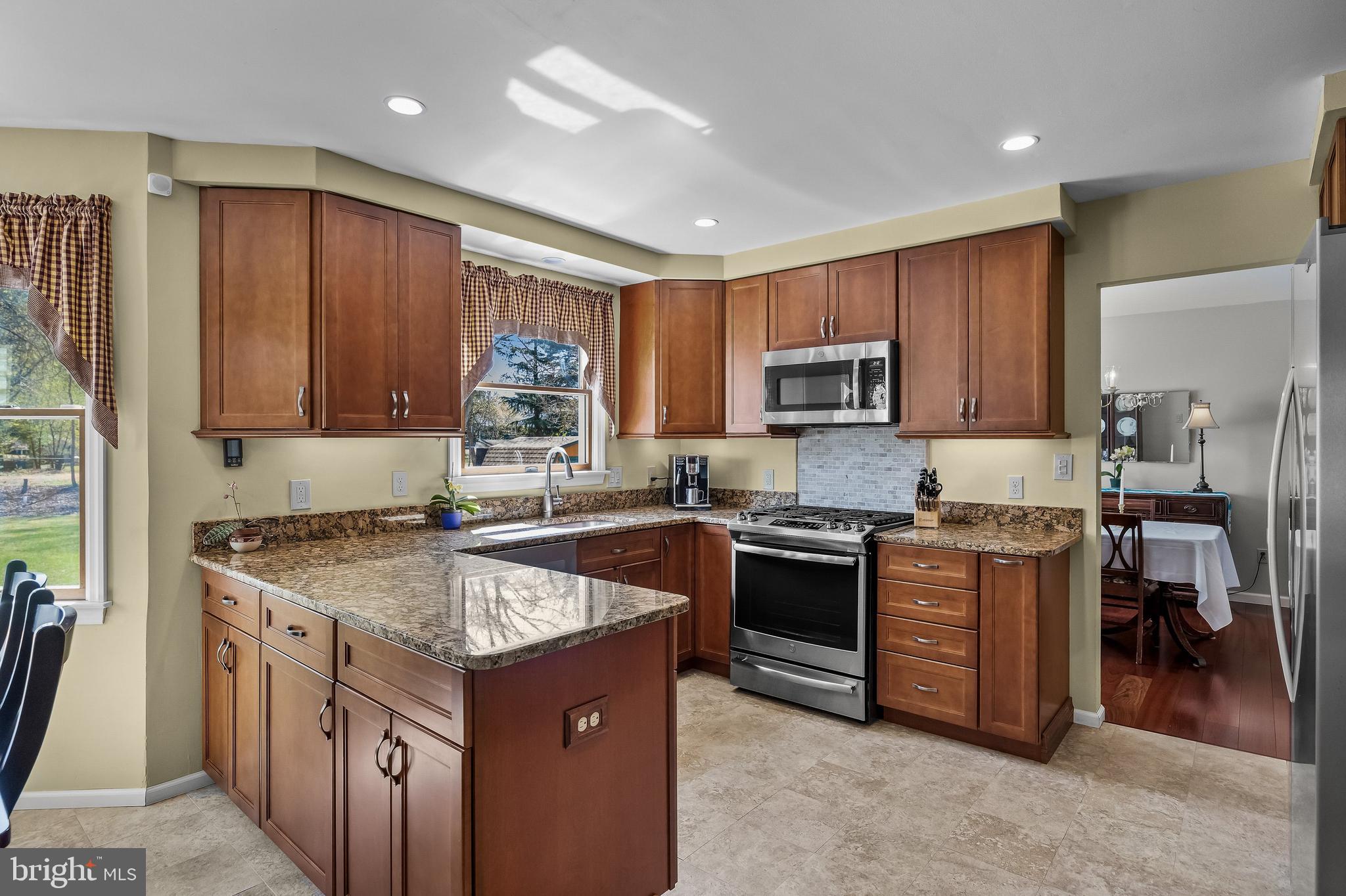 446 Prospect Avenue West Berlin, NJ 08091 - Photo 13 of 54 a kitchen with stainless steel appliances granite countertop a stove top oven a sink dishwasher and wooden cabinets with wooden floor