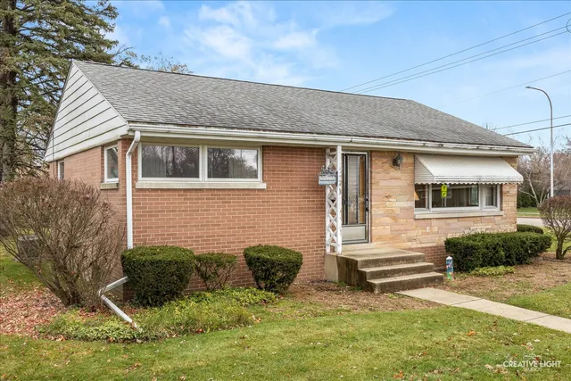 a view of a house with backyard and couches under an umbrella
