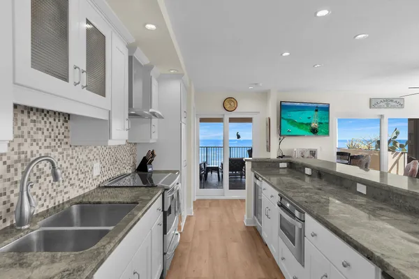a kitchen with stainless steel appliances granite countertop a table and chairs in it