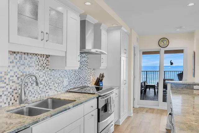 a spacious kitchen with stainless steel appliances granite countertop a sink stove and refrigerator