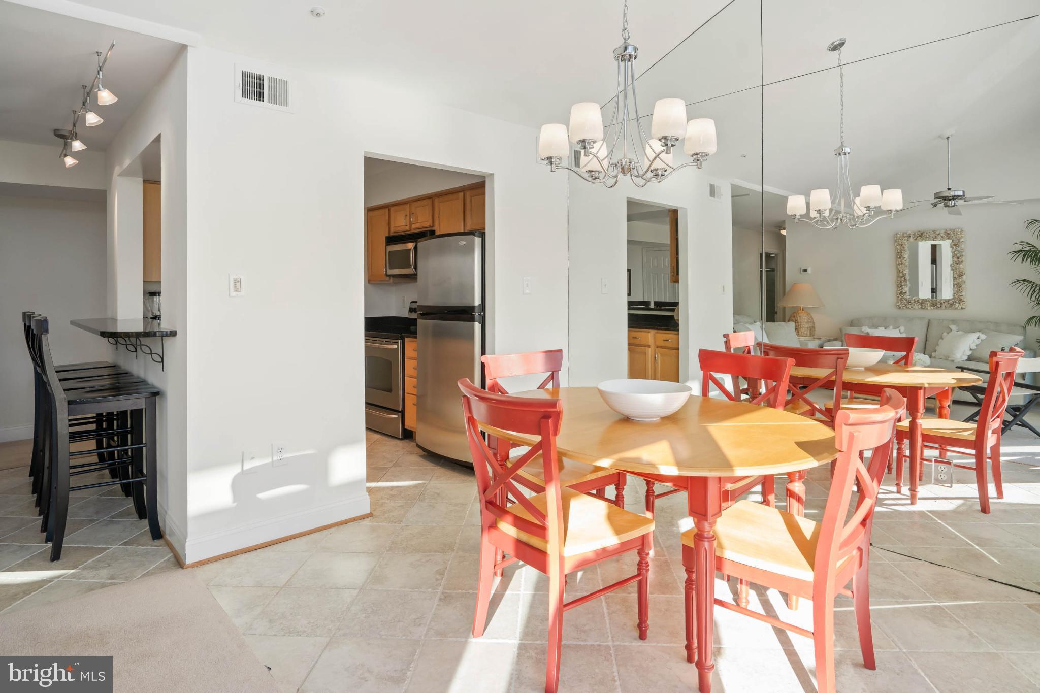 13908 North Ocean Road, Unit 10A Ocean City, MD 21842 - Photo 10 of 29 a dining room filled chandelier and kitchen view