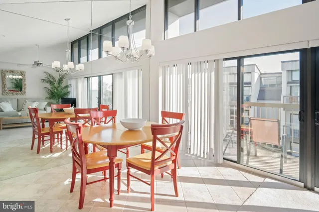 a dining room filled chandelier and kitchen view
