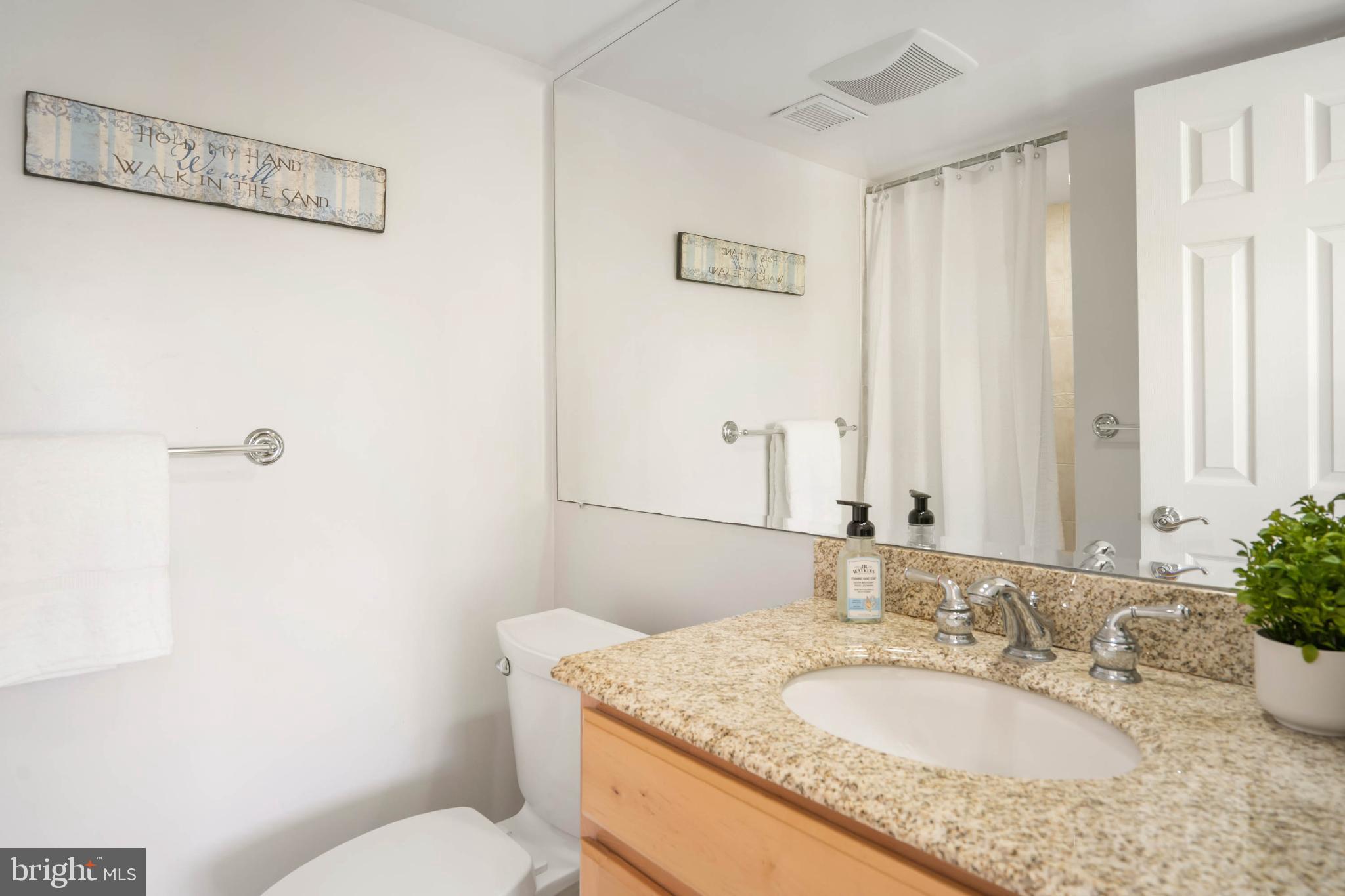 13908 North Ocean Road, Unit 10A Ocean City, MD 21842 - Photo 19 of 29 a bathroom with a granite countertop sink a mirror and a toilet