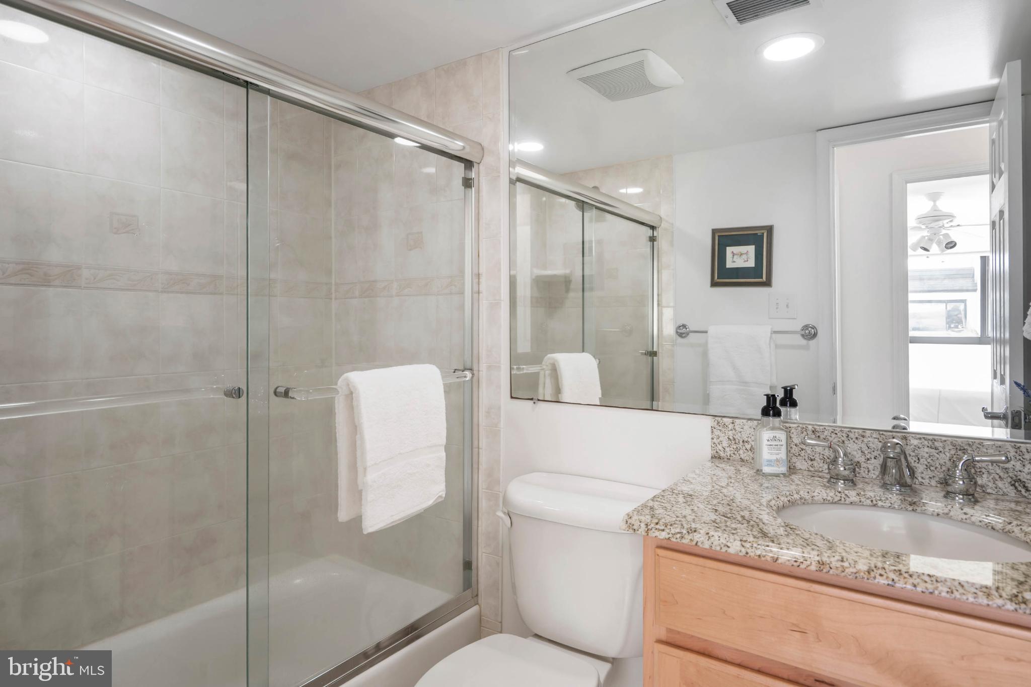 13908 North Ocean Road, Unit 10A Ocean City, MD 21842 - Photo 22 of 29 a bathroom with a granite countertop sink a toilet and shower