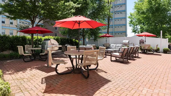 a view of a backyard with chairs and umbrella