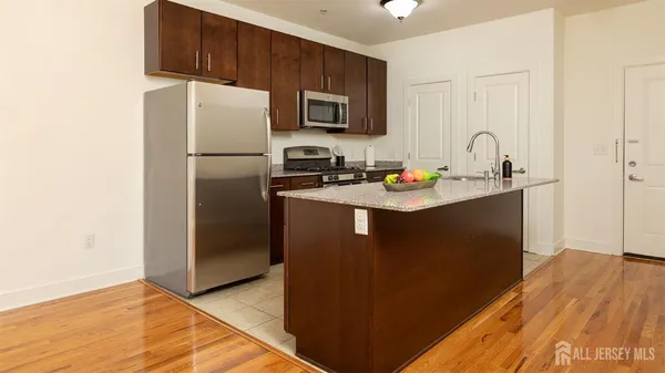 a kitchen with stainless steel appliances granite countertop a refrigerator stove top oven a sink and dishwasher