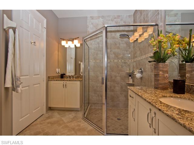 6545 Monterey Point Naples, FL 34105 - Photo 7 of 10 a bathroom with a granite countertop sink a mirror a potted plant and shower
