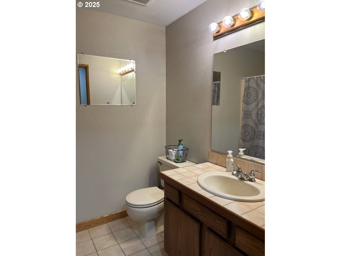 1101 Southwest 37th Street Pendleton, OR 97801 - Photo 15 of 22 a bathroom with a sink toilet and mirror