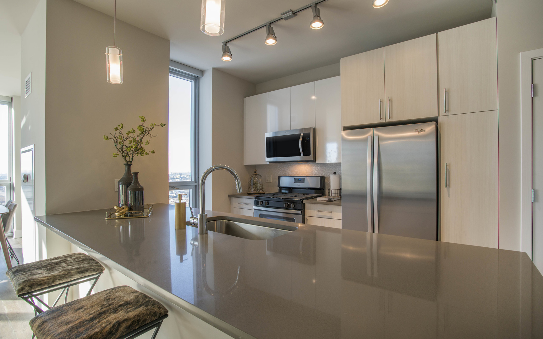 801 South Financial Place, Unit 605 Chicago, IL 60607 - Photo 7 of 31 a kitchen with granite countertop a refrigerator a sink a stove and white cabinets with wooden floor