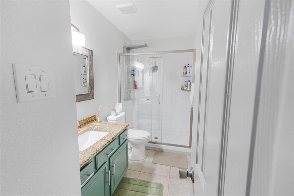 2813 Ridgemere Drive Flower Mound, TX 75028 - Photo 11 of 18 a bathroom with a granite countertop sink a toilet and shower