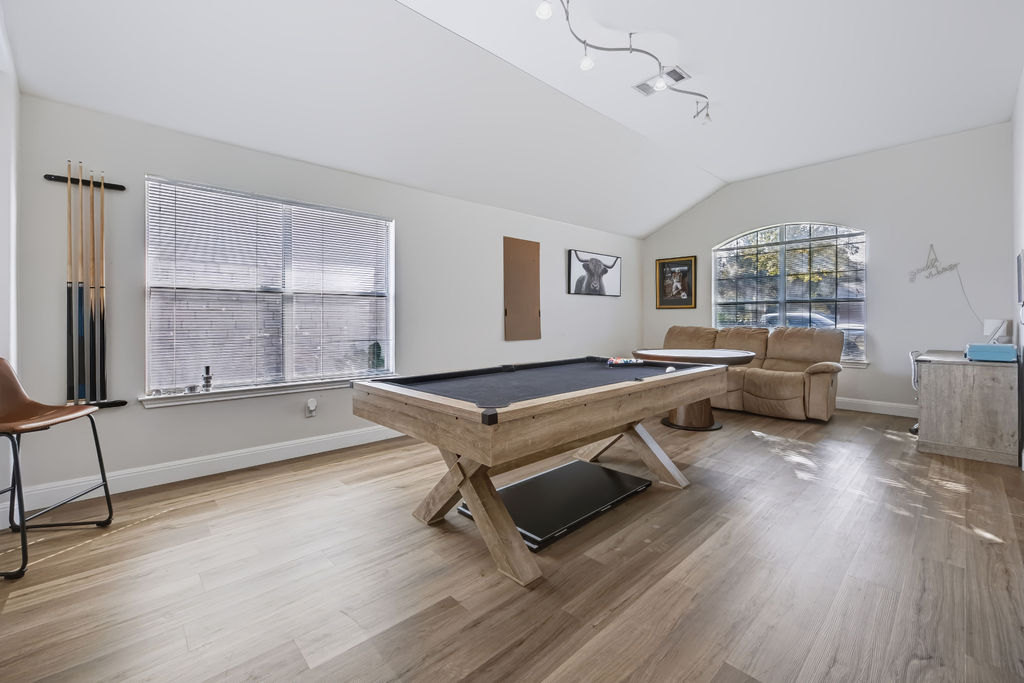 400 Ranier Lane Round Rock, TX 78665 - Photo 7 of 36 Vaulted ceilings and wood-style flooring elevate this versatile recreation room.