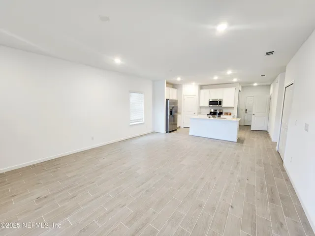 a view of a kitchen with a sink and a refrigerator