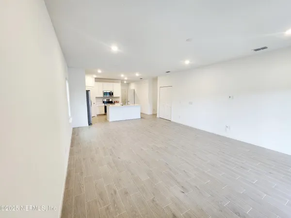 a view of a hallway with wooden floor and entryway