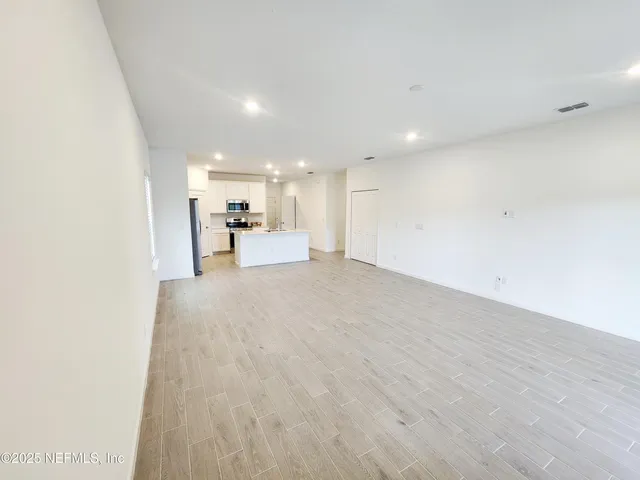 a view of a hallway with wooden floor and entryway