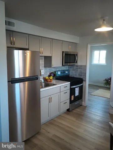 a kitchen with stainless steel appliances granite countertop a refrigerator a stove a sink and a microwave