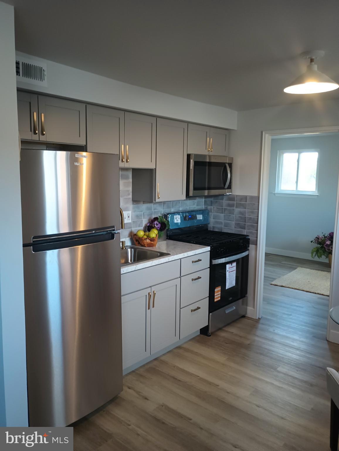9712-26 Bustleton Avenue, Unit 8 Philadelphia, PA 19115 - Photo 2 of 6 a kitchen with stainless steel appliances granite countertop a refrigerator a stove a sink and a microwave
