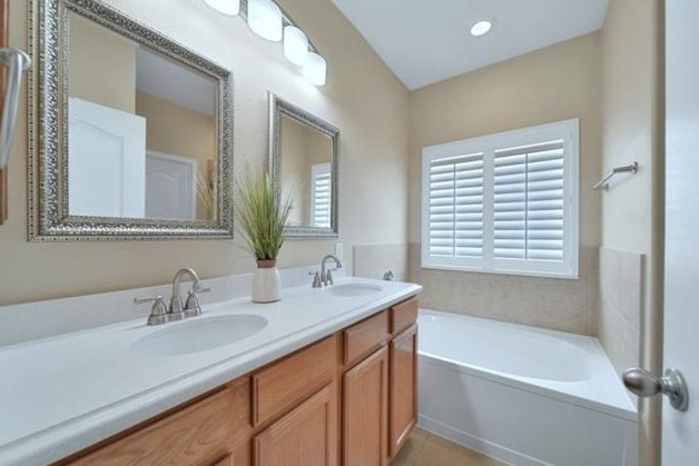 622 West Newport Bend Katy, TX 77494 - Photo 5 of 9 a bathroom with a sink double vanity mirror and a bathtub