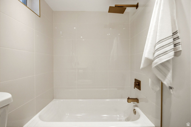 1187 East Ridgedale Circle Millcreek, UT 84106 - Photo 26 of 49 Bathtub with a bronze-finish showerhead, bronze-finish faucet, and glossy white subway tile surround