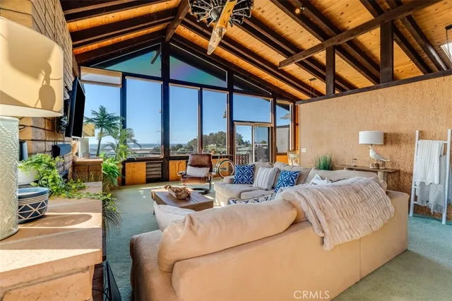 a living room with furniture a flat screen tv and a floor to ceiling window