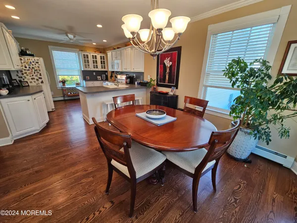 a dining room filled chandelier and wooden floor