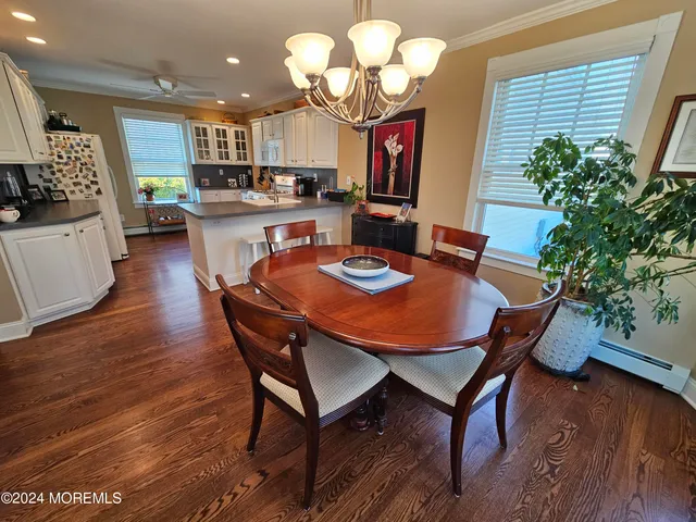 a dining room filled chandelier and wooden floor