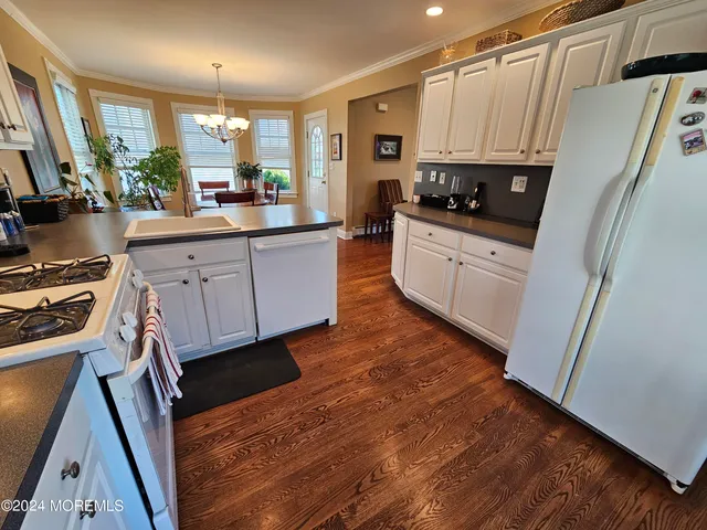 a kitchen with white cabinets and black appliances