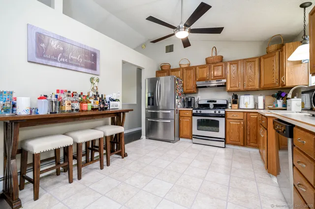 a kitchen with granite countertop stainless steel appliances a sink counter space and a window