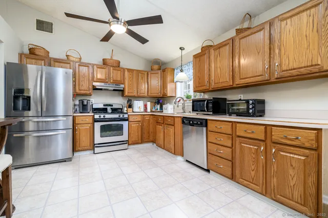 a dining room with wooden floor a chandelier a wooden table and chairs