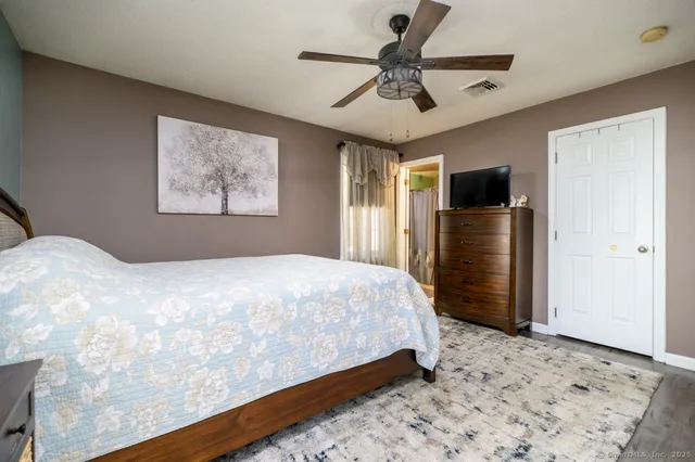 a bedroom with a large bed and a flat screen tv