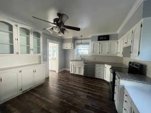 a kitchen with a stove and white cabinets