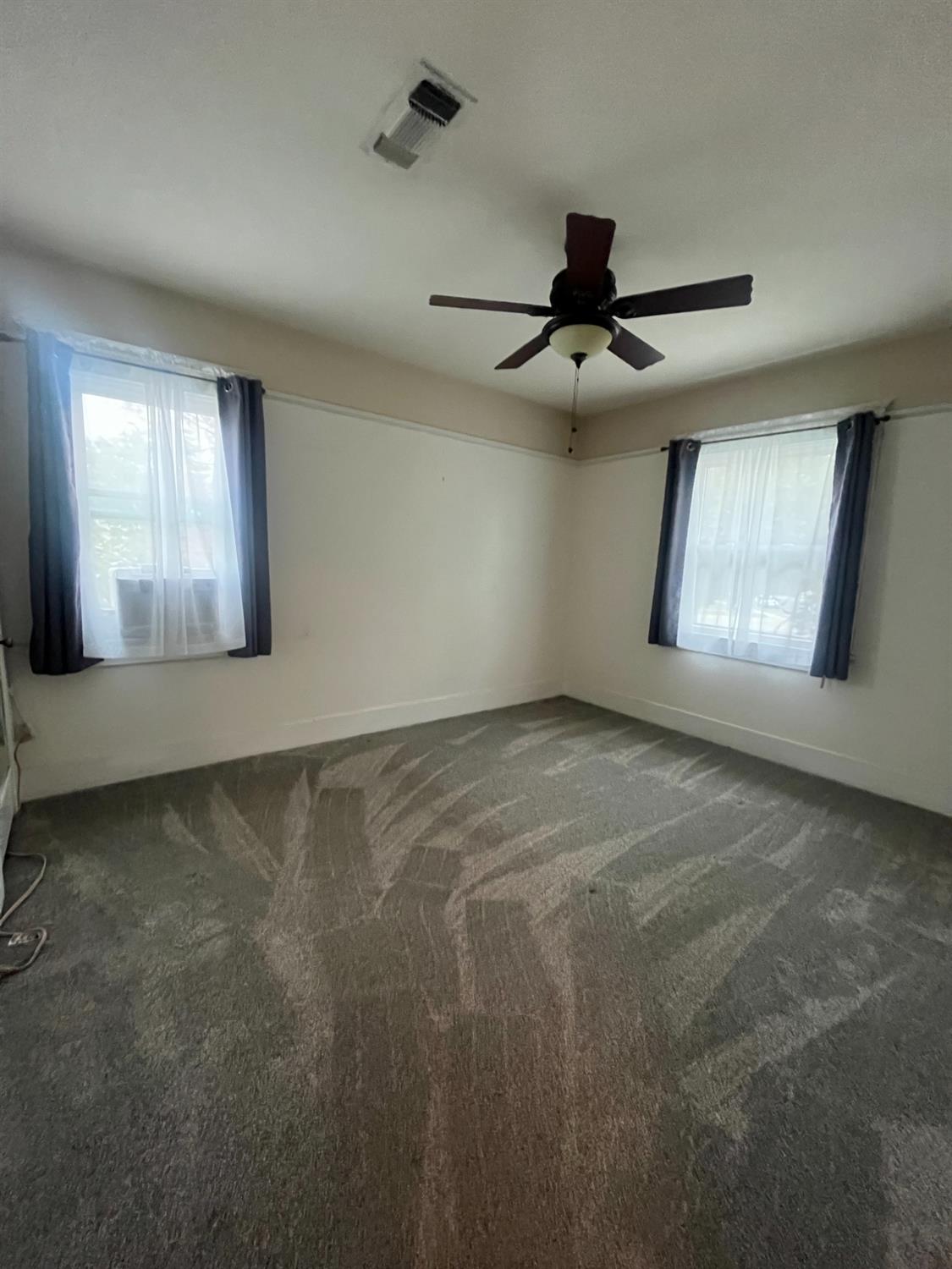 471 South Reed Avenue Reedley, CA 93654 - Photo 16 of 54 en empty room with windows and ceiling fan