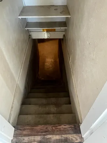 a kitchen with granite countertop a stove a sink and white cabinets with wooden floor