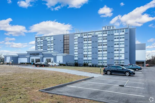 a view of a buildings and cars park