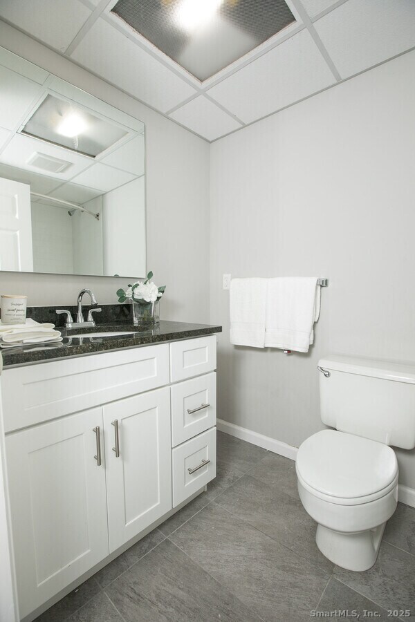 225 Lordship Boulevard, Unit 1F Stratford, CT 06615 - Photo 9 of 19 a bathroom with a granite countertop toilet and sink