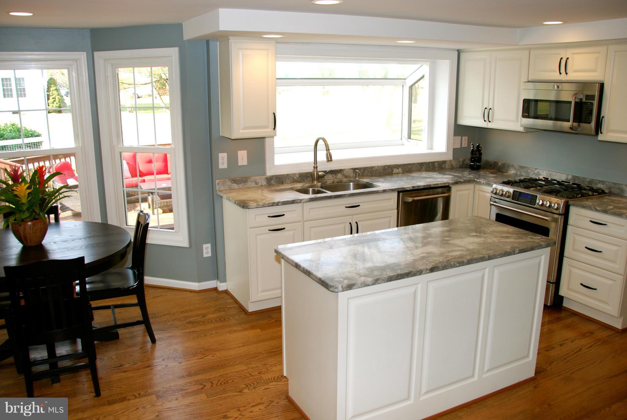 3112 Newcastle Lane Riva, MD 21140 - Photo 4 of 27 a kitchen with stainless steel appliances granite countertop a stove a sink a microwave a dining table and chairs