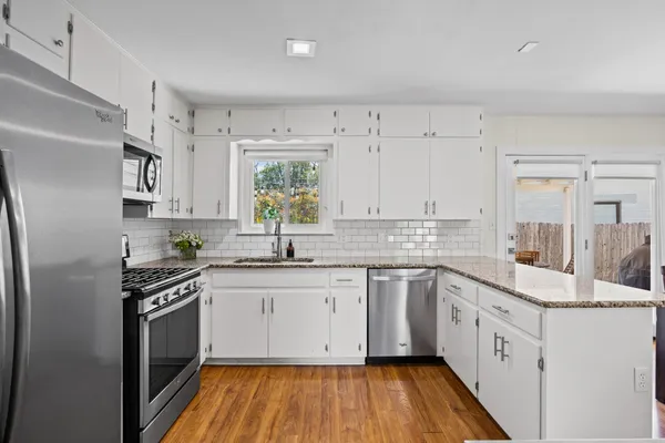 a kitchen with a white cabinets sink and stainless steel appliances
