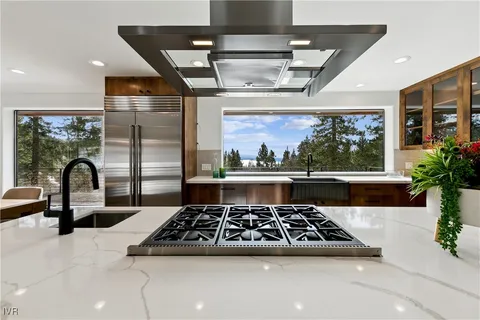 a large kitchen with stainless steel appliances granite countertop a stove a sink a counter space and cabinets