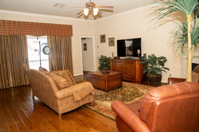 a living room with furniture a flat screen tv and a large window